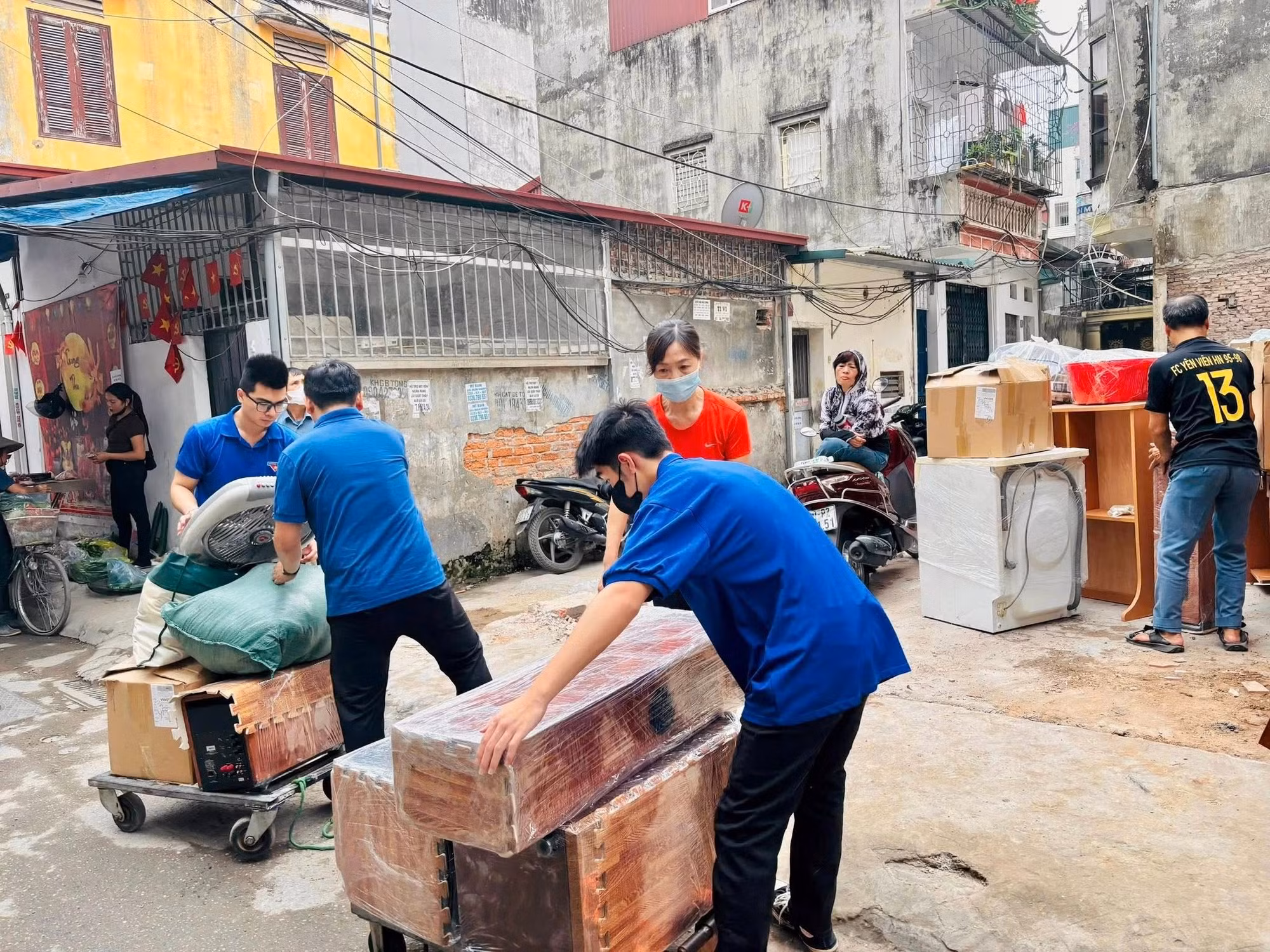 Hình ảnh thanh niên tình nguyện hỗ trợ người dân di chuyển đồ đạc