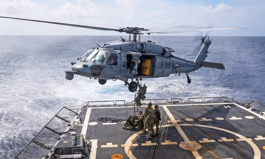 Các kỹ thuật viên xử lý vật liệu nổ lên trực thăng MH-60R Sea Hawk, thuộc Phi đội Trực thăng Tác chiến Biển 14, từ boong tàu khu trục tên lửa dẫn đường lớp Arleigh Burke USS Frank E. Petersen Jr. ngày 1/1/2026. Ảnh: US Navy.