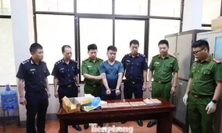 Đối tượng (giữa) và tang vật vụ án. 