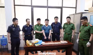 Đối tượng (giữa) và tang vật vụ án. 