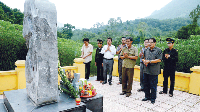 Anh Lê Văn Lợi (thứ 2 hàng đầu từ phải sang) thắp hương trước bia tưởng niệm liệt sĩ Phạm Văn Lộc tại Khuôn Tát, xã Phú Đình, huyện Định Hóa (17/8/2014). ảnh: Đồng Khắc Thọ