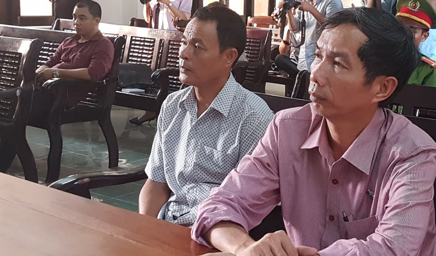 Ngư dân Trần Văn Liên (áo trắng, bên trái) cùng luật sư tại phiên tòa xét xử sơ thẩm. Ảnh H. Văn.