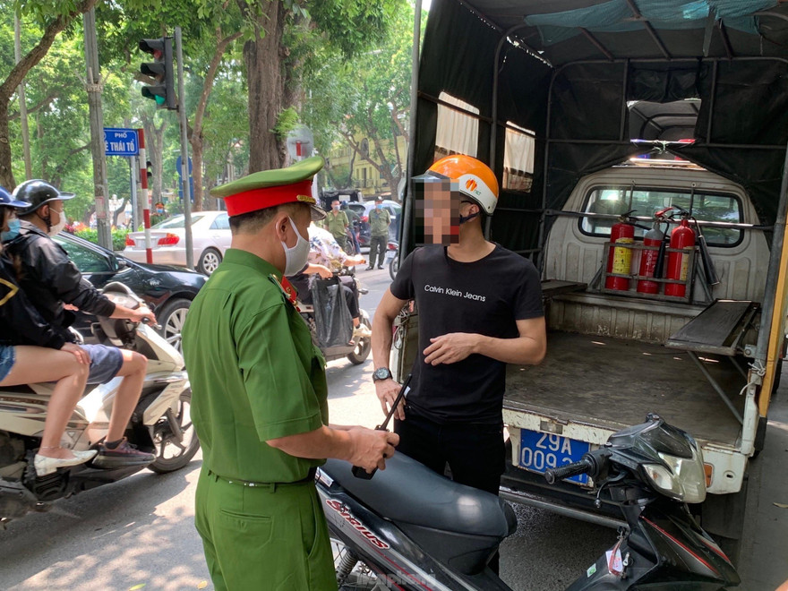 Lực lượng chức năng tuyên truyền, xử phạt trường hợp không đeo khẩu trang. Ảnh Việt Linh