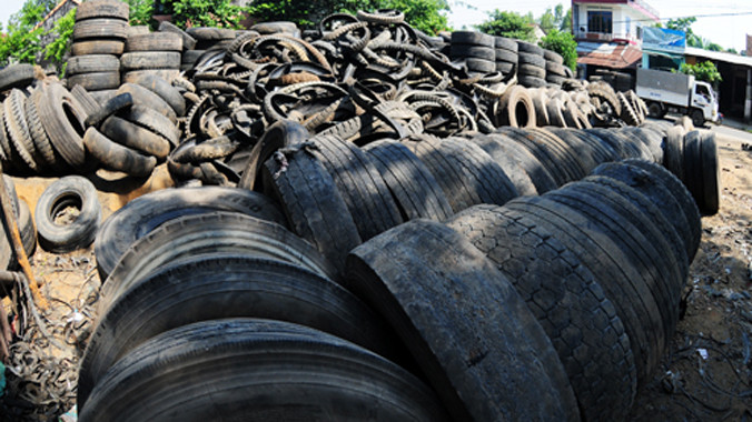 Lốp xe phế thải chất cao như núi, tràn từ vườn nhà dân ra đường cái ở thôn Hòa Bình, xã Nghĩa Hòa, huyện Tư Nghĩa. 