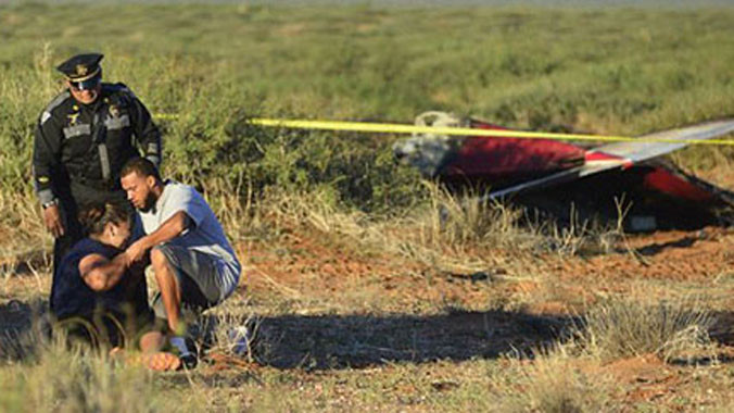 Người nhà của một trong số các nạn nhân khóc thảm thiết bên xác chiếc máy bay gặp nạn. Ảnh: AP