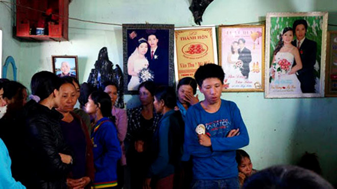 Anh Chương (áo xanh) thất thần trước cái chết của vợ và hai con. Ảnh: Dân Việt