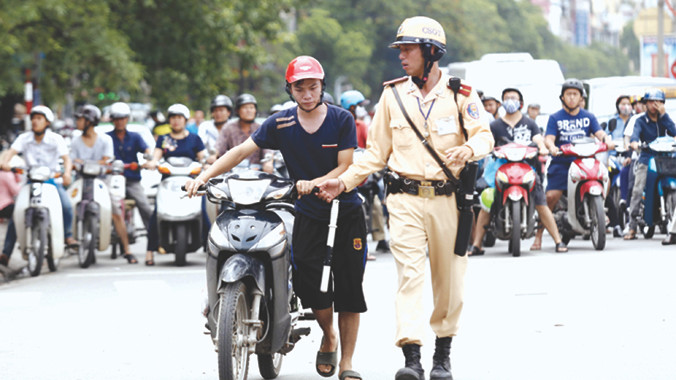 Ngay cả CSGT cũng khó phân biệt mũ giả - mũ thật (ảnh chụp chiều 1/7 tại Hà Nội). Ảnh: Như Ý