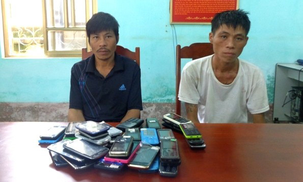 Hà Văn Ơn (áo trắng) và Hoàng Văn Trần cùng tang vật bị bắt giữ. Ảnh: Công an cung cấp