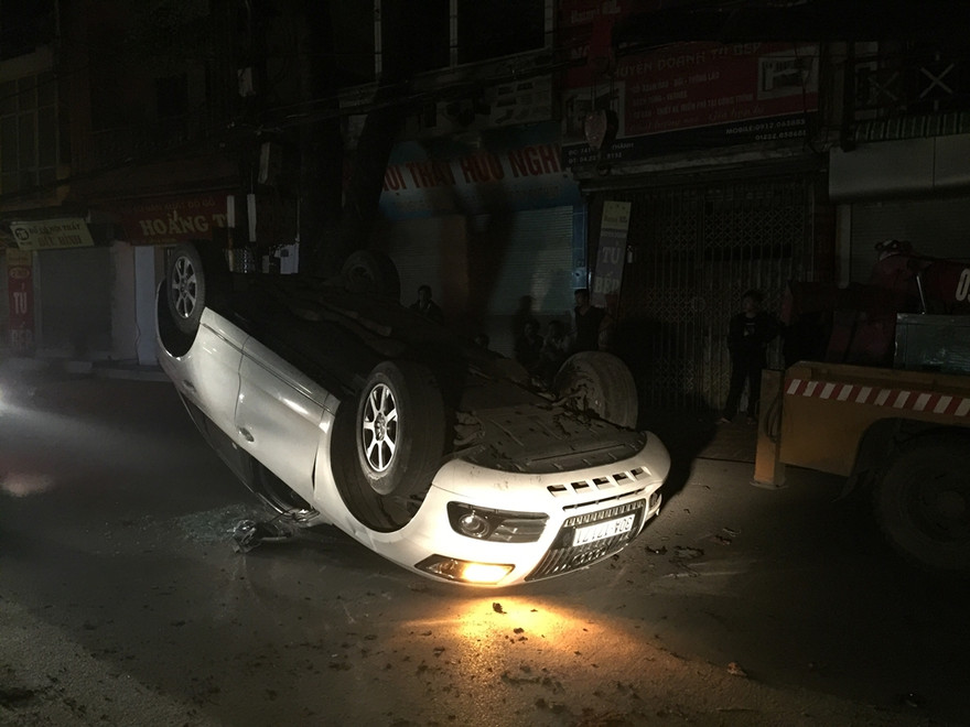 Chiếc xe lật ngửa, đèn vẫn nháy, kính vỡ tung tóe.