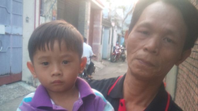 Anh Thanh bảo vệ dân phố đang bế cháu bé. Ảnh: Phùng Bắc.