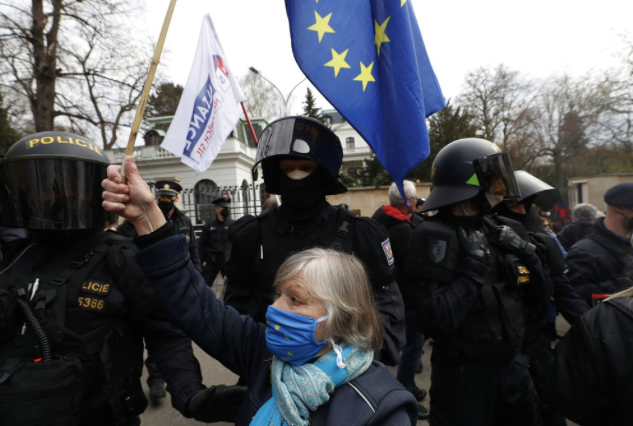 Một phụ nữ vẫy cờ EU trước đại sứ quán Nga ở CH Séc. (Ảnh: AP)