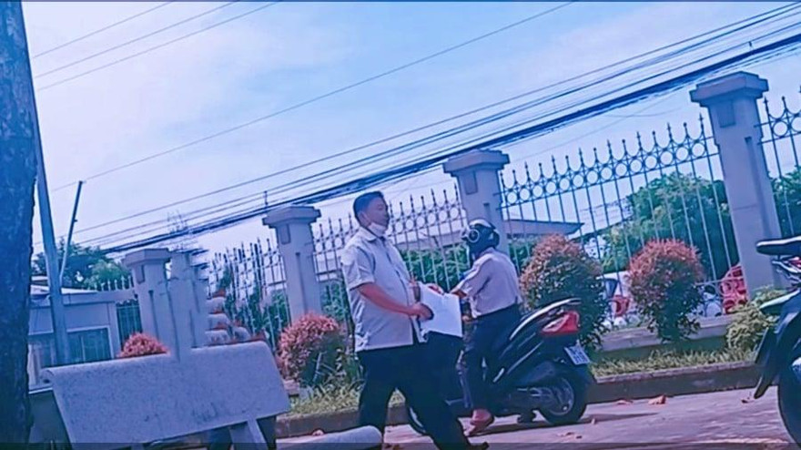 Ông Đỗ Thanh Bình (đứng) và ông Nguyễn Duy Lâm (ngồi xe máy) sau phiên xử. Cả 2 ông cùng được tại ngoại hầu tòa. Ảnh: Tân Châu