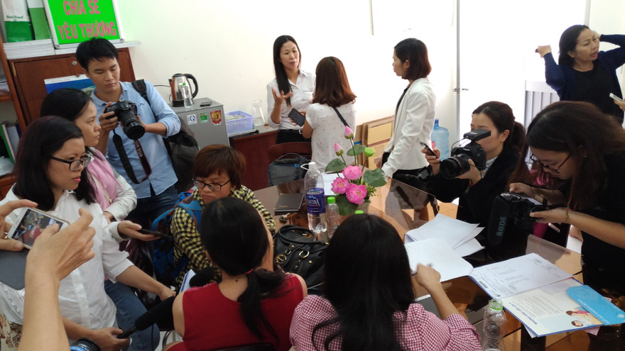 Chị M.C (áo đỏ, quay lưng) đang làm việc với các phóng viên tại Hội Bảo vệ quyền trẻ em ngày 13/3.