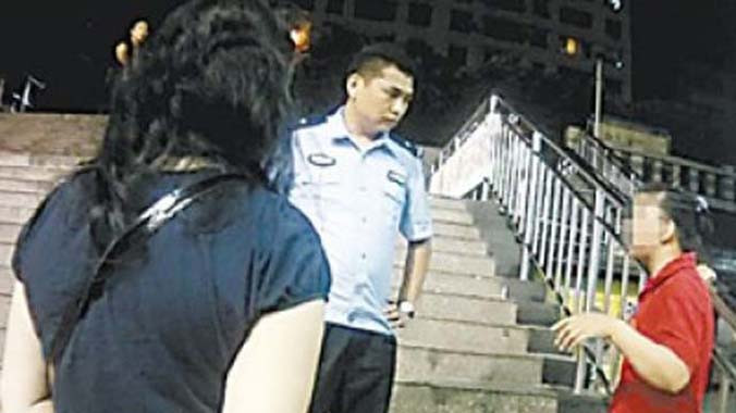 Bà mẹ (mặc áo đỏ) giải thích với cảnh sát lý do bà lén chụp ảnh các nữ nhân viên trong siêu thị.