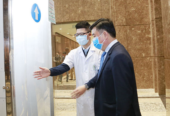 Đại biểu dự chương trình kỷ niệm 90 năm Đảng bộ thành phố Hà Nội thực hiện khử khuẩn toàn thân. Ảnh: KTĐT