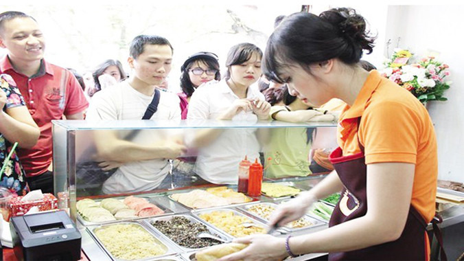 Minh Nhật tất bật trong ngày khai trương cửa hàng bánh mỳ. Ảnh: TL.