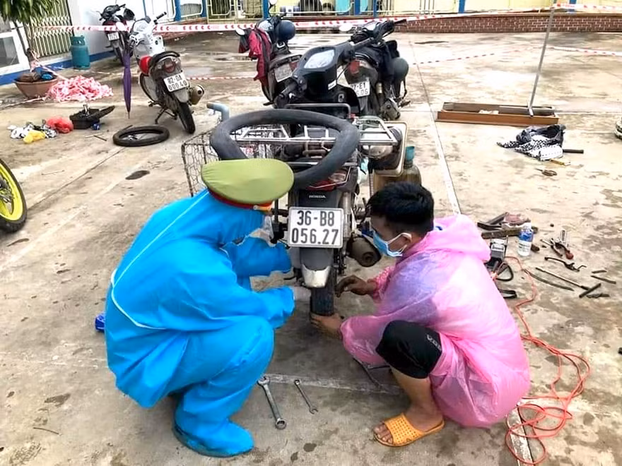 Các chiến sĩ Công an huyện Ngọc Hồi, Kon Tum sửa xe giúp người dân từ phía Nam về quê qua địa bàn