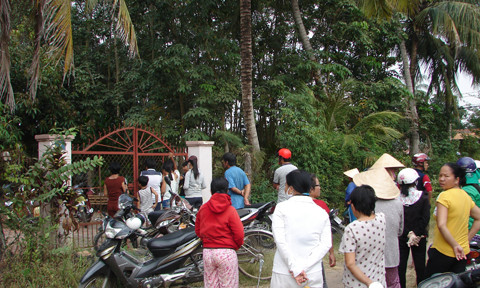Người dân hiếu kì vây quanh trước nhà nạn nhân.