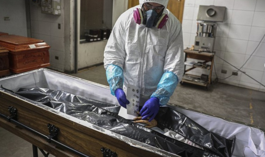 Nhân viên y tế lấy dấu vân tay của một phụ nữ chết vì COVID-19 ở Chile ngày 27/6. (Ảnh: AP)