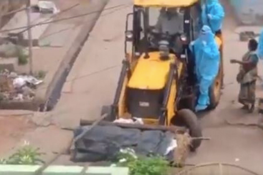Ảnh chụp từ clip ghi lại cảnh chiếc xe ủi chuyển thi thể bệnh nhân chết vì COVID-19.