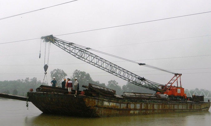 Xà lan đứt neo trôi tự do trên sông.