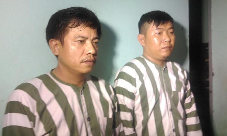 Hai nghi can Phạm Tiến Mạnh (phải) và Hạp Tiến Bắc tại cơ quan điều tra. Ảnh Việt Văn