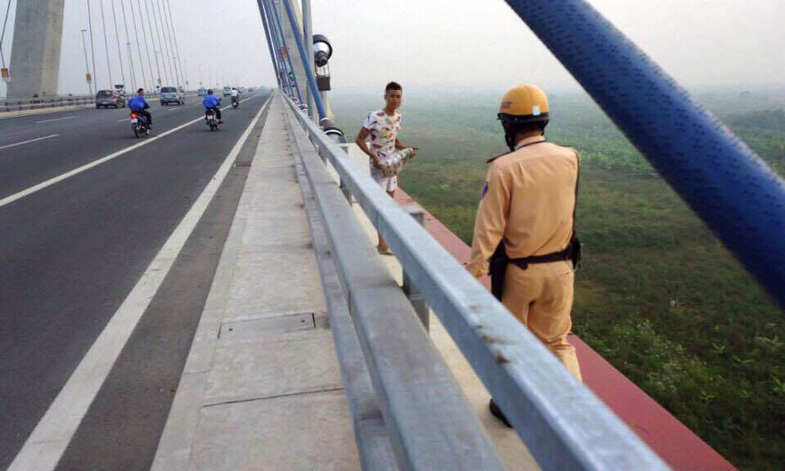 Chiến sĩ CSGT dùng biện pháp nghiệp vụ túm lấy nam thanh niên và khuyên giải.