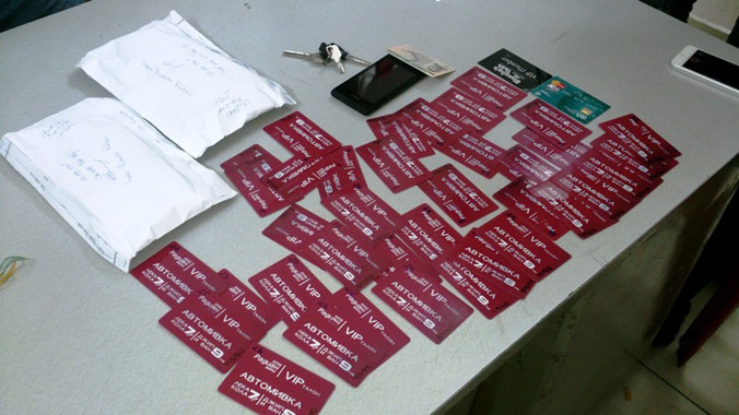 Tang vật thu giữ tại cơ quan công an: Tiền mặt và thẻ ATM giả. Ảnh Việt Văn.