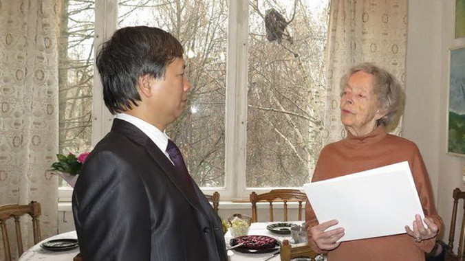 Cán bộ Đại sứ quán Việt Nam tại Liên bang Nga trao thư cảm ơn cho bà Sofia Lenidovna Korchikova. Ảnh: Duy Trinh/Vietnam+.