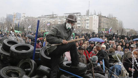 Một người biểu tình thân Nga canh gác chướng ngại vật bên ngoài một tòa nhà chính quyền ở Donetsk, phía đông Ukraina hôm 10/4. Ảnh: AP