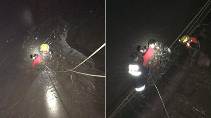 Cô bạn gái cũ (áo đỏ) bị ngập trong bùn sau khi nhảy xuống sông. Đội cứu hộ phải dùng dây thừng buộc quanh người để kéo cô gái lên.