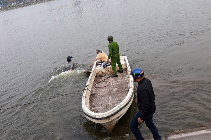 Người đàn ông ngâm mình dưới hồ Linh Đàm được đưa lên bờ. Ảnh: FB
