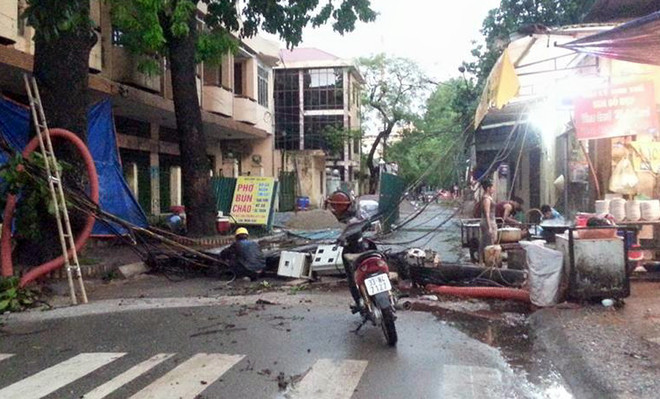 Nhiều cột điện đổ chắn ngang đường gây mất điện. 