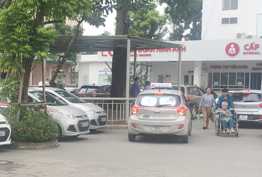 Do bị taxi hoạt động trong các bệnh viện từ chối đi "cuốc" ngắn, nhiều bệnh nhân đã được người nhà đẩy xe ra ngoài đường để bắt xe khác. Ảnh: Anh Trọng