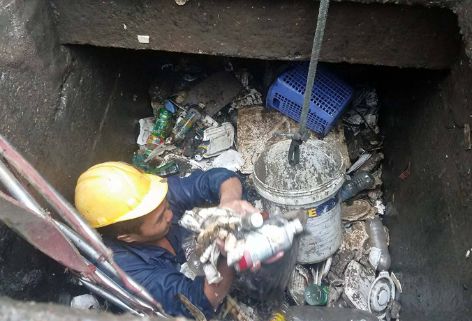 Rác ngập dưới miệng cống thoát nước đường Nguyễn Hữu Cảnh.