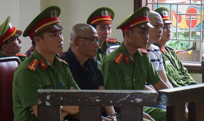 Phan Đình Tuấn (áo đen) và Hồ Sự Cơ (áo sọc trắng) trước vành móng ngựa.