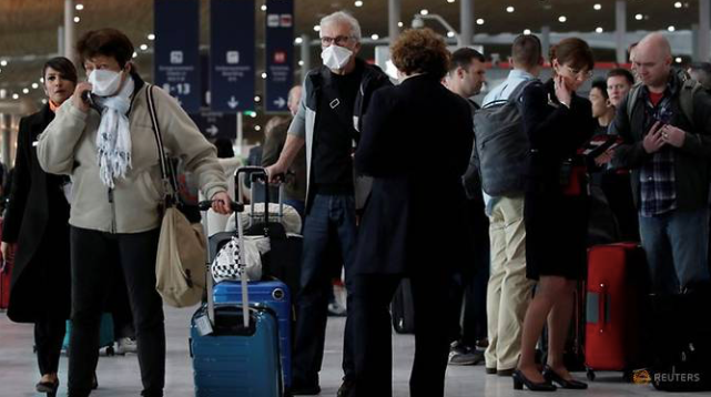 Các hành khách đeo khẩu trang tại sân bay Charles de Gaulle ngày 12/3. (Ảnh: Reuters)