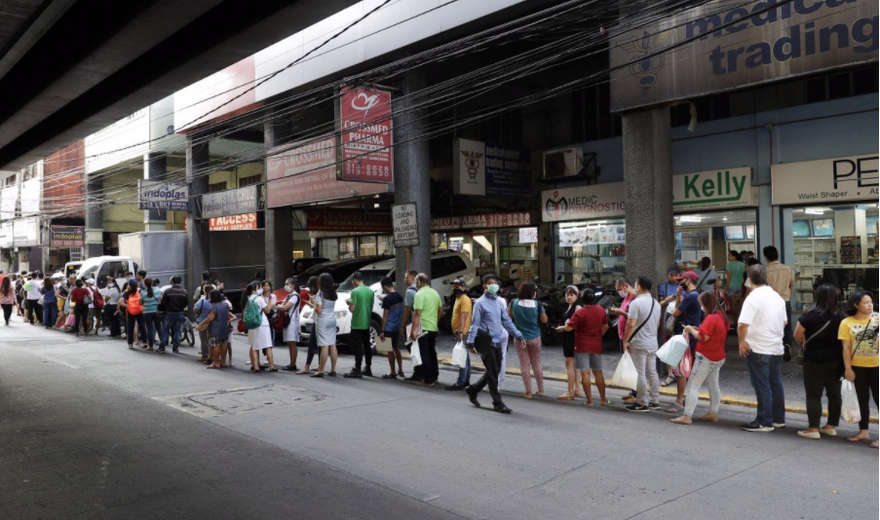 Người dân xếp hàng mua khẩu trang trước một cửa hàng ở Manila. (Ảnh: AP)