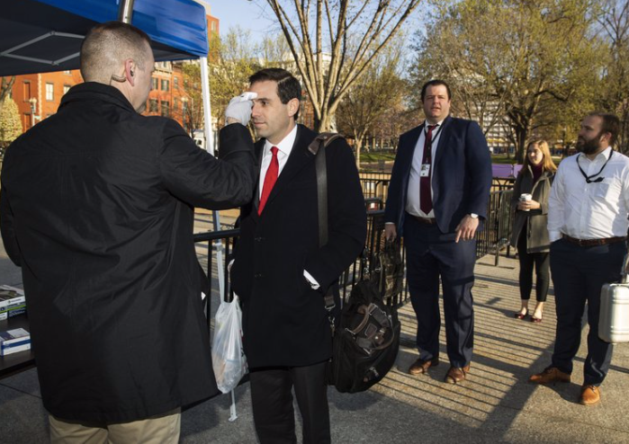 Các phóng viên theo dõi Nhà Trắng được kiểm tra thân nhiệt trước khi vào phòng họp. (Ảnh: AP)