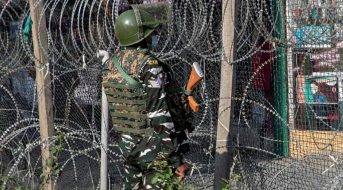 Một lính Ấn Độ đứng gác gần hàng rào dây thép gai ở Srinagar ngày 12/10. (Ảnh: AP)