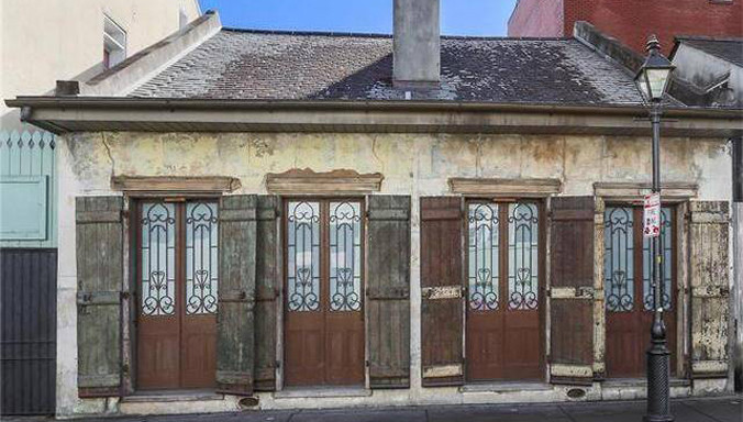 Mặt trước của ngôi nhà bị xem là "ổ chuột" với những cánh cửa gỗ mục nát và tường loang lổ.