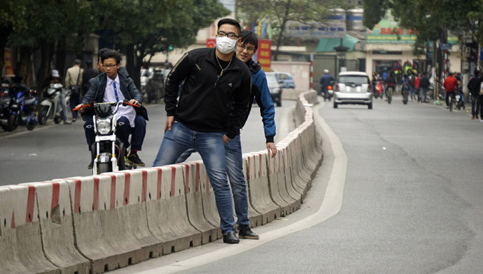 Phố Lê Thanh Nghị (quận Hai Bà Trưng) bố trí giải phân cách cứng suốt chiều dài phố, không có vạch dành cho người đi bộ cũng như cầu vượt, việc đi lại giữa 2 bên đường đều phải trèo qua dải phân cách.