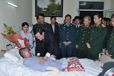 Chủ tịch nước Trương Tấn Sang ân cần thăm hỏi, động viên Thượng úy QNCN Đinh Văn Dương. Ảnh qdnd.vn