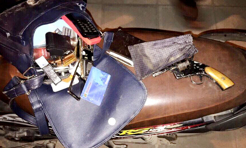 Chiếc túi xách nữ cùng nhiều điện thoại, thẻ ATM, và khẩu súng côn xoay.