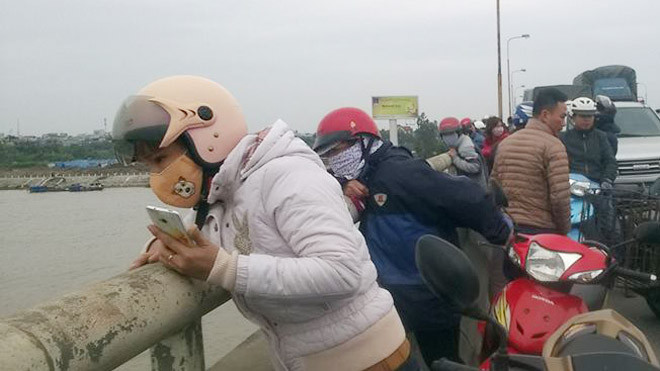 Người dân hiếu kỳ theo dõi việc trục vớt thi thể nạn nhân ở cầu Phú Lương sáng 26/2