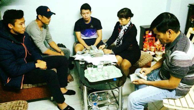 Ngọc Hải (trái) cùng đại diện CLB SLNA đến tận nhà Anh Khoa (phải) để trao toàn bộ số tiền đền bù. 