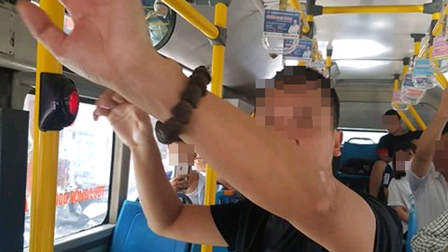 Ông H. (áo đen) đã lén lút "tự sướng" trên xe buýt dù xung quanh đang có nhiều hành khách. Ảnh: CTV