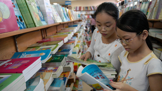  Học sinh tiểu học lựa chọn sách giáo khoa tại một cửa hàng sách trên đường Lý Thường Kiệt (Hà Nội). Ảnh: Hồng Vĩnh