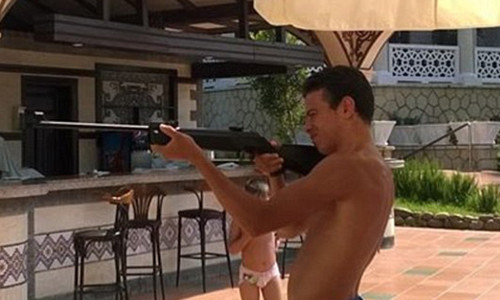 Bilal cởi trần, tay cầm khẩu súng ngắm bắn. Ảnh: Facebook.