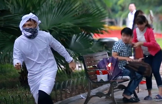 Hai bạn trẻ ngồi ghế giật mình vì bị "đốt bom". Ảnh cắt từ clip